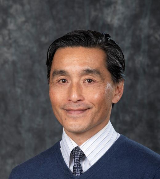 Man in blue sweater over a dress shirt and tie