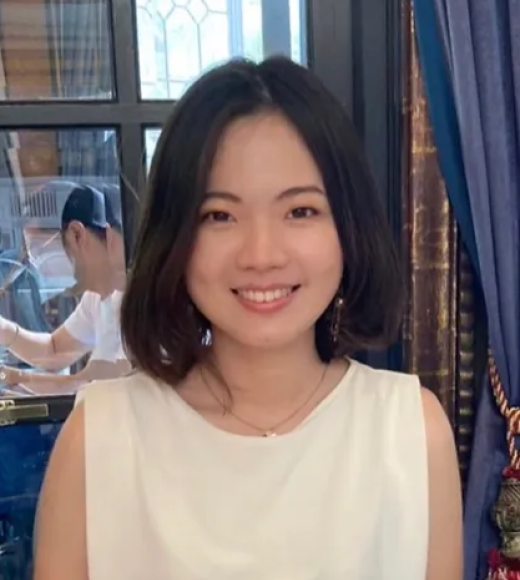 Vivian Wong in a white dress standing in front of a window